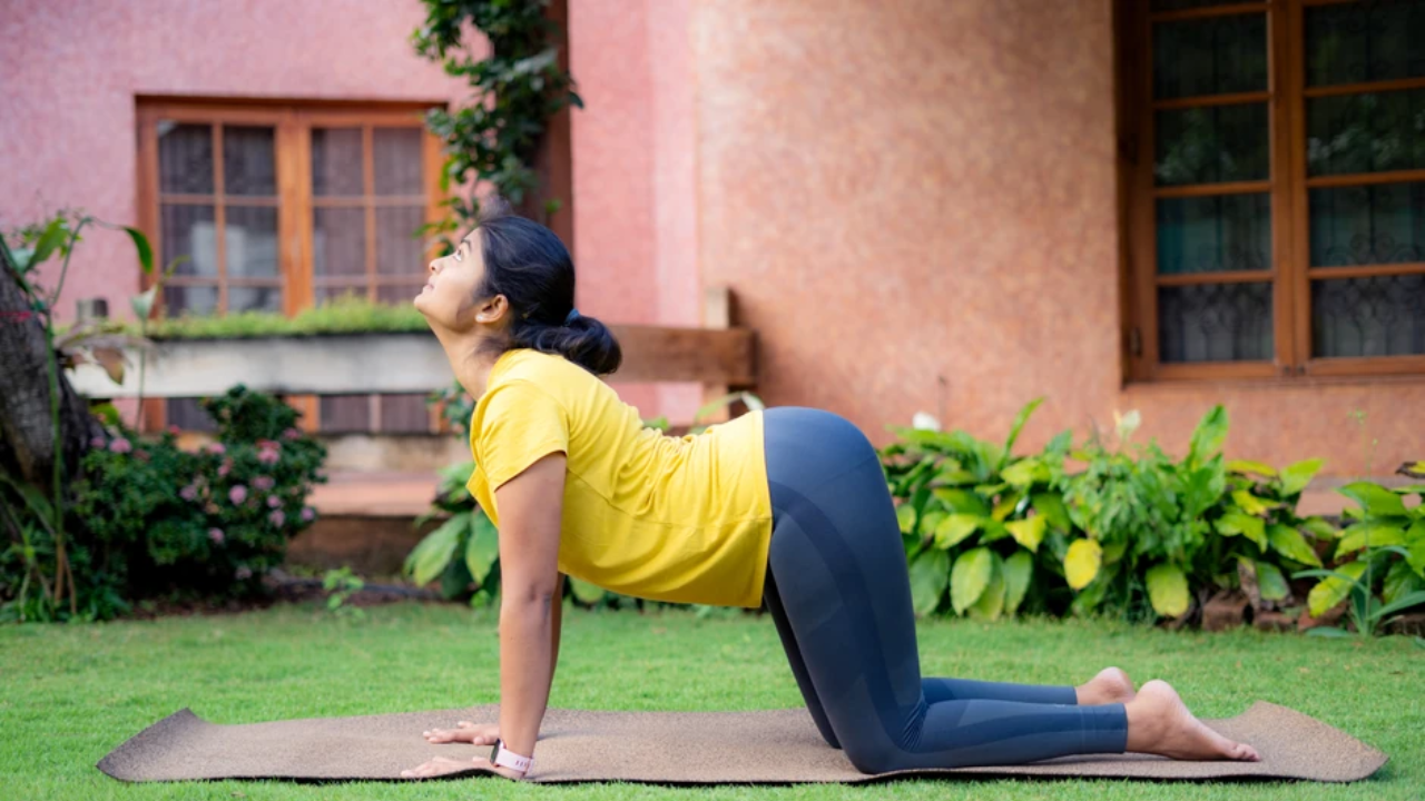 Woman doing cat-cow pose for day 1 yoga detox challenge