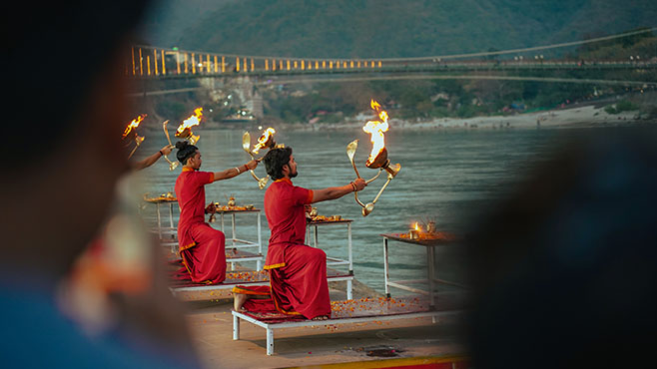 Ganga Aarti Rishikesh evening sacred river ritual with fire lamps and devotees gathered on the ghat beside the holy Ganges river at sunset