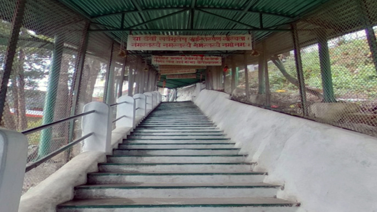 Kunjapuri Temple paved stairs leading up to the temple entrance with devotees climbing in the morning