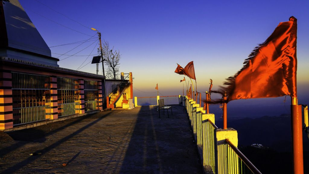 Kunjapuri Temple trek route through forest path with trekkers walking towards the hilltop temple in early morning