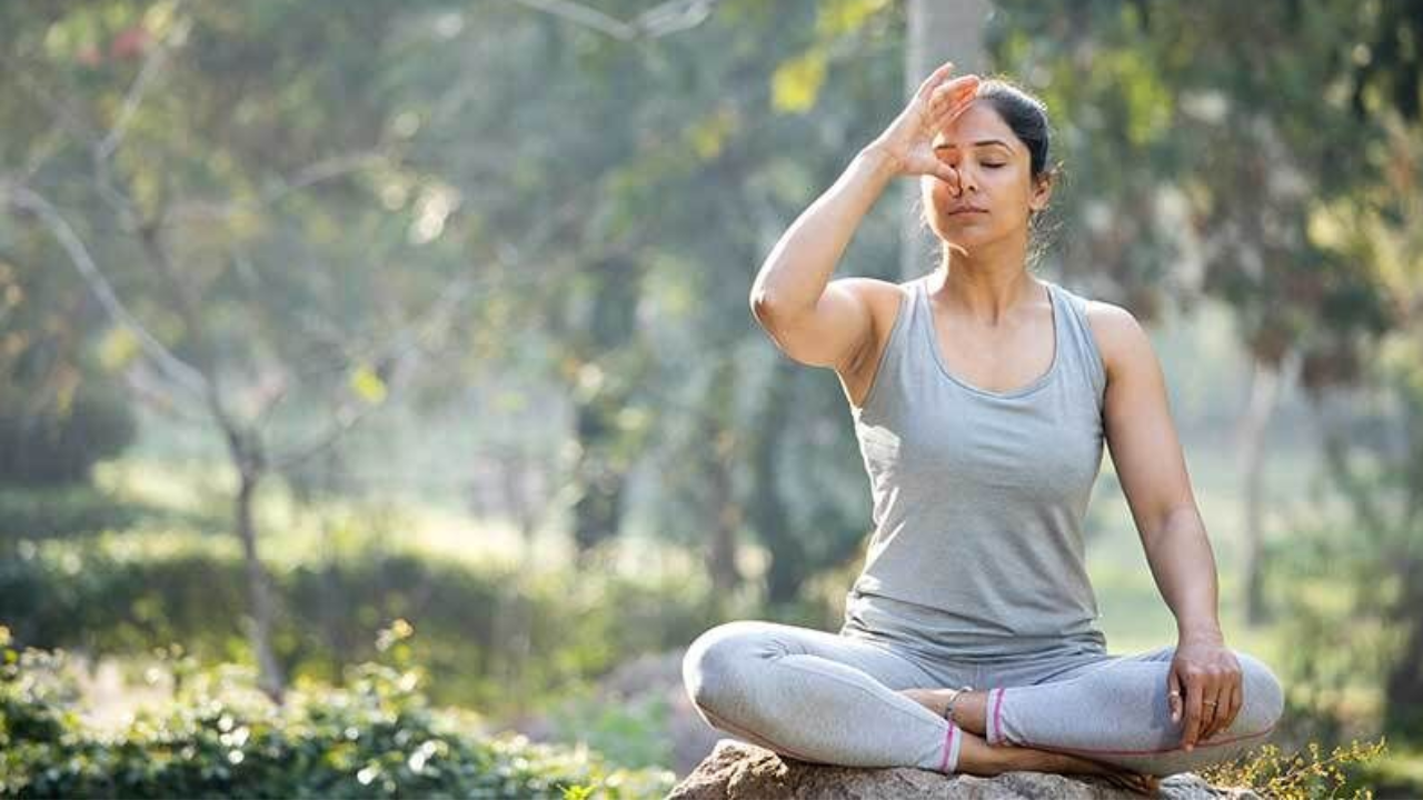 Person practicing meditation following the Eight Limbs of Yoga path to enlightenment