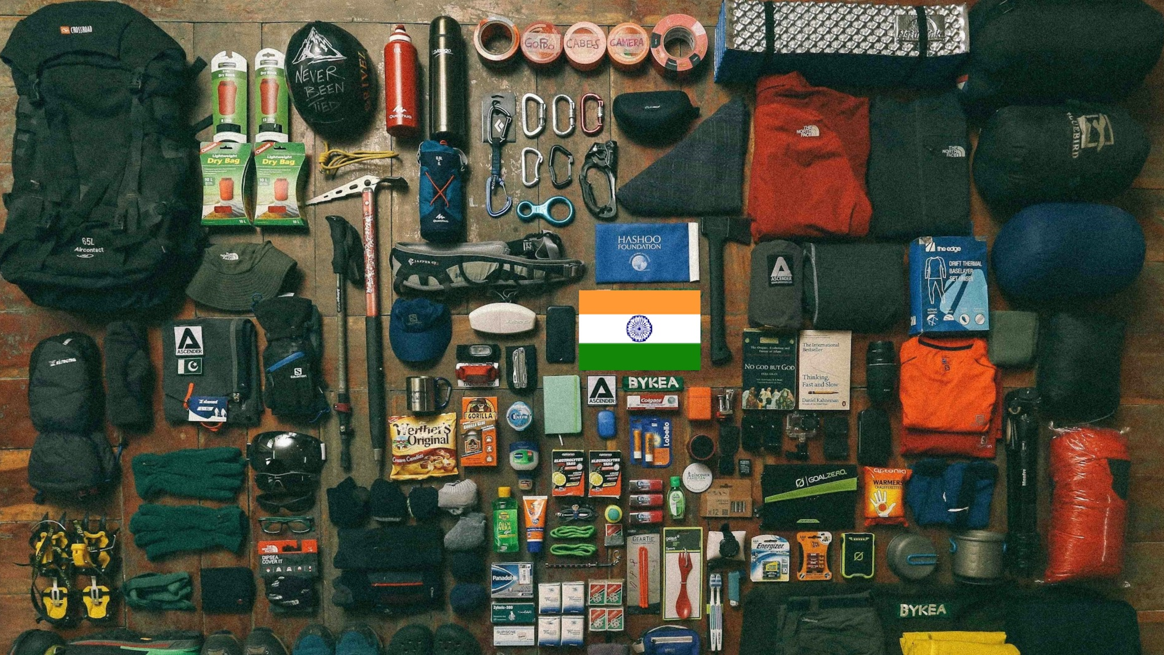 Essential trekking gear and equipment laid out including boots, backpack, clothing layers, and safety items