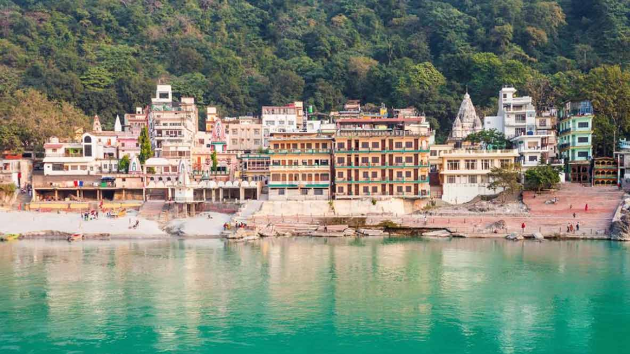 Cozy ashram room overlooking Ganges with yoga mat and Himalayan sunrise view