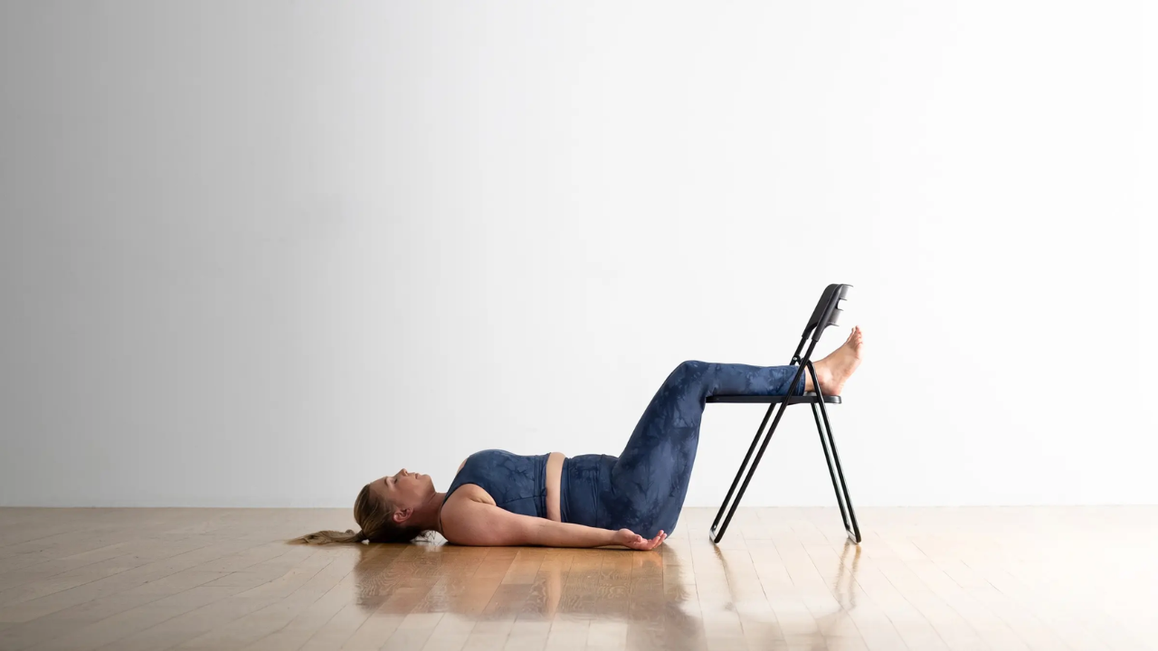 Person in correct Savasana body position on yoga mat showing arms legs and spine alignment