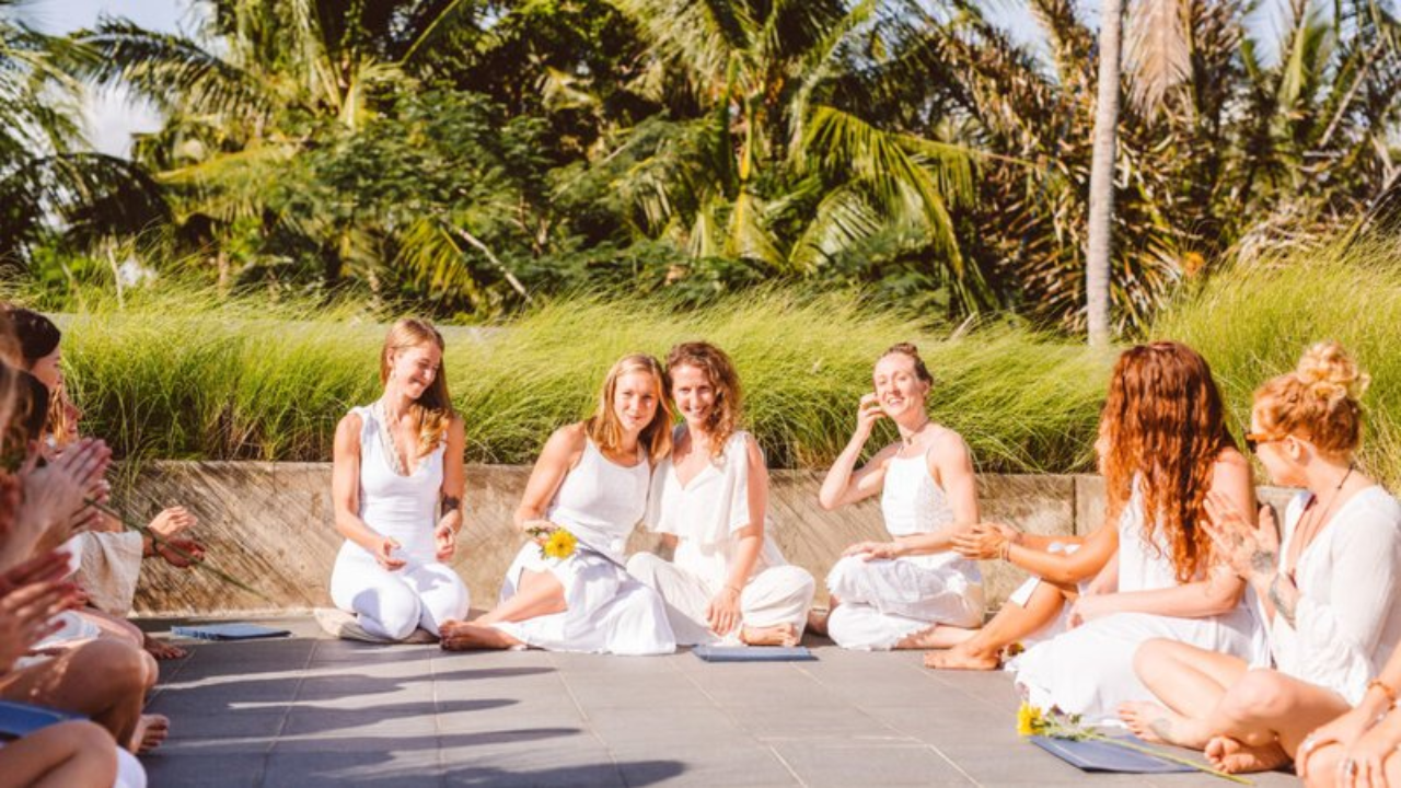 Yoga retreat guest resting and writing in journal during afternoon free time on first day near a riverside in Rishikesh