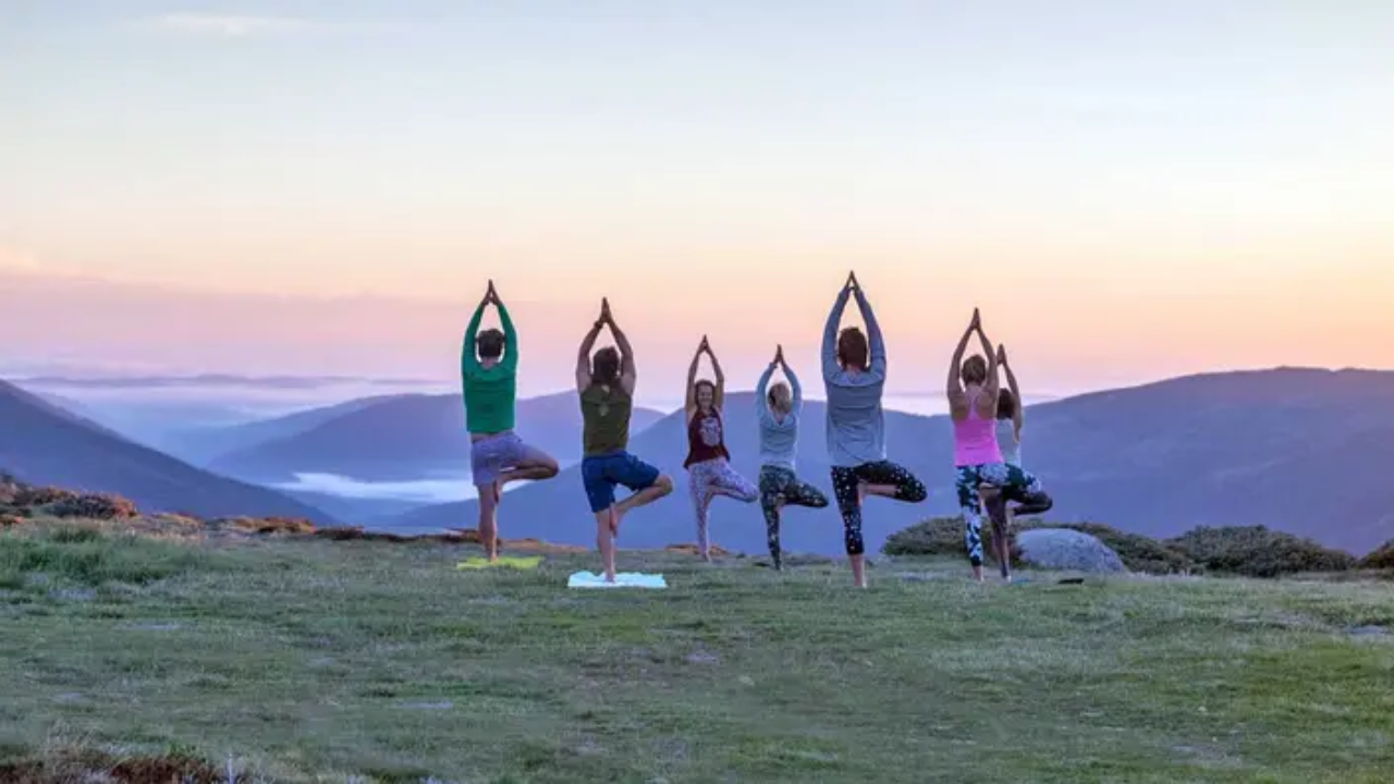 Yoga retreat daily schedule showing morning yoga practice session in Rishikesh at sunrise