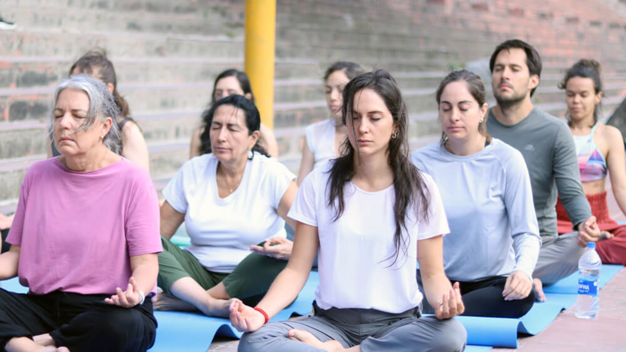 Mixed group of yoga retreat students at all levels doing morning practice together in Rishikesh