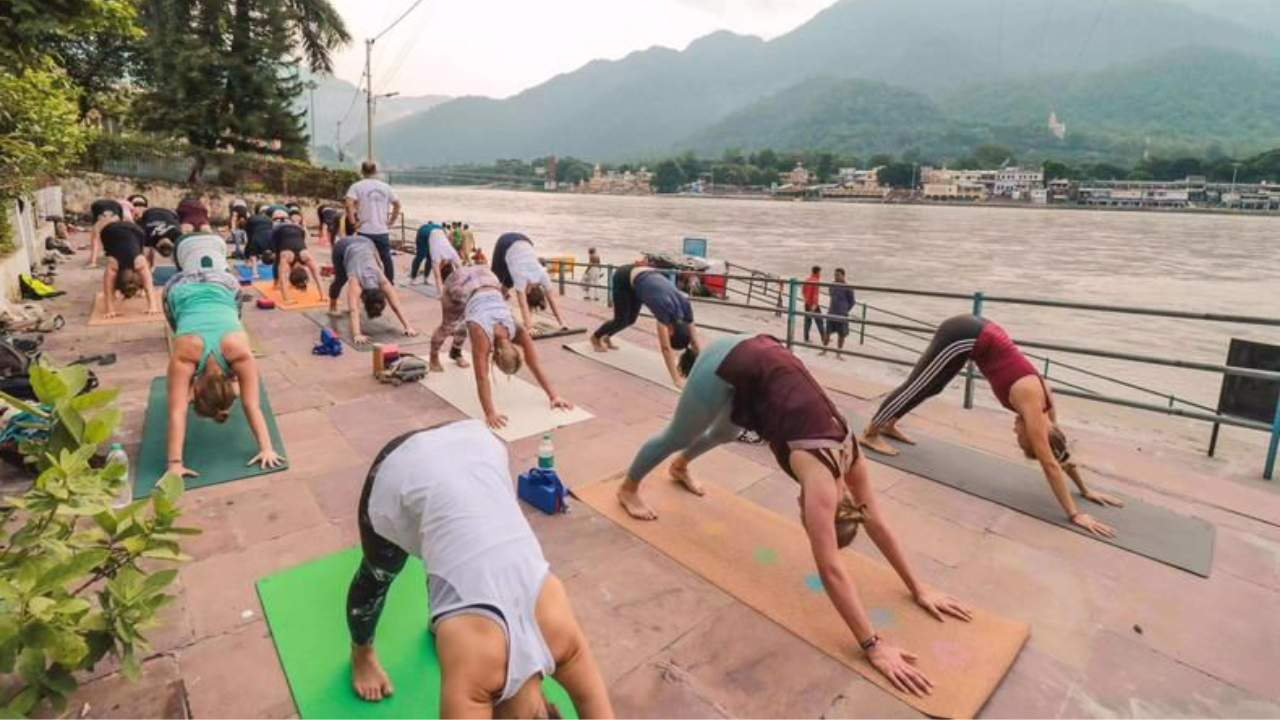 Person healing from stress and burnout through yoga and meditation at riverside retreat in Rishikesh