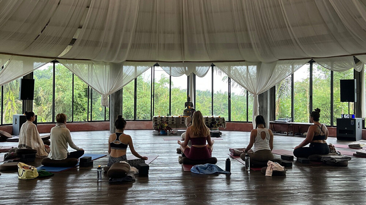 Yoga retreat meditation session in Rishikesh with participants sitting in silence during guided morning meditation practice