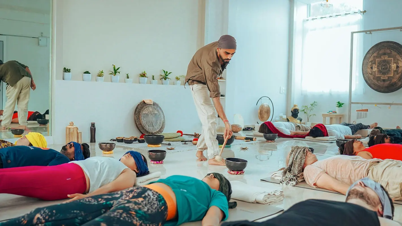 Group of beginner yoga students in morning class on first day of retreat in a bright open yoga hall with natural light
