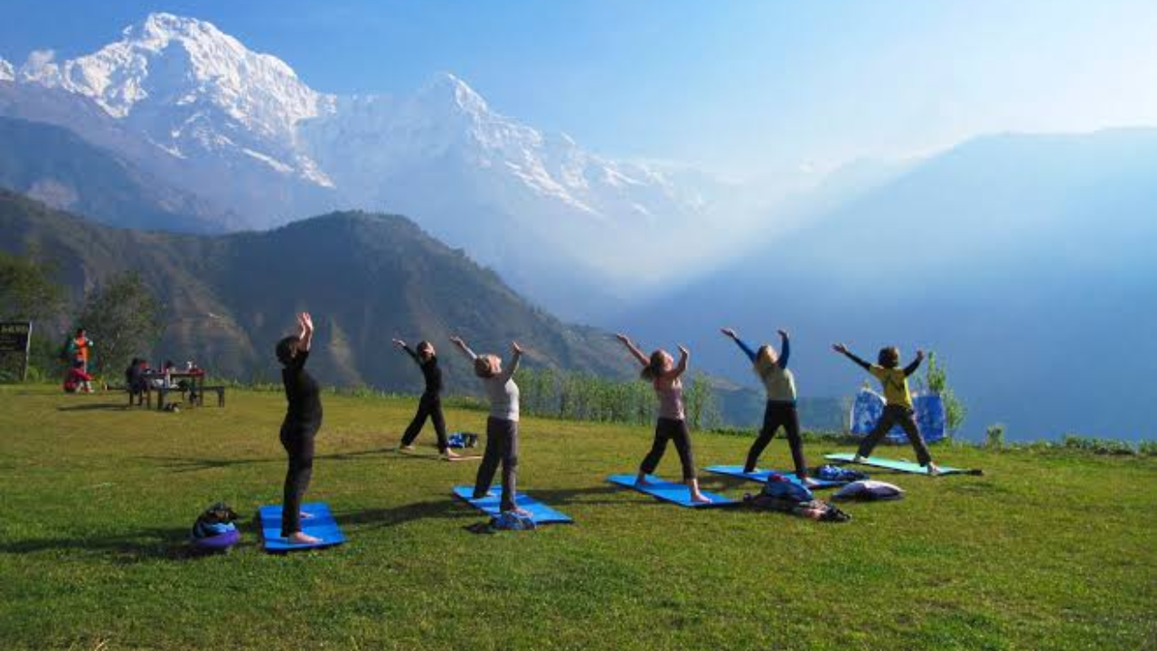 Yoga retreat in Rishikesh with view of the Ganges river and Himalayan hills in the background during morning practice