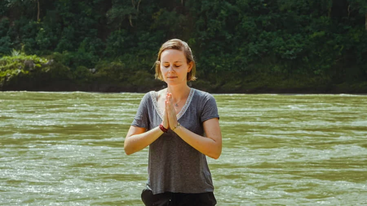 Solo traveler arriving at a yoga retreat in Rishikesh with the Ganges river and mountains in the background